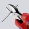 A red pair of pliers cuts through a metal nail. The pliers have black metal jaws. The image emphasises the strength and precision of the tool.