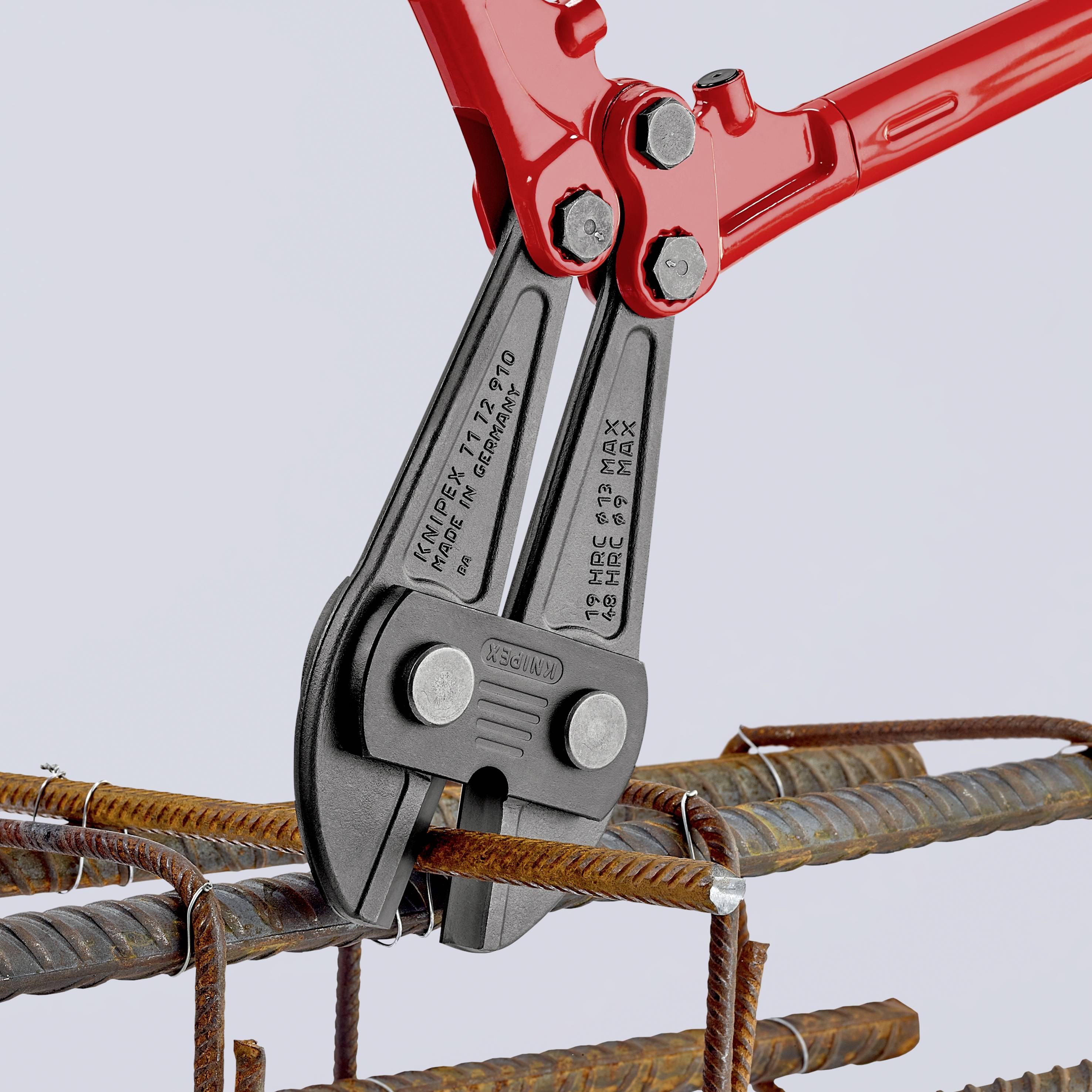 A red bolt cutter cuts reinforcement iron. Three steel rods are arranged in a metal frame.