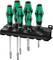 Six green and black screwdrivers with ergonomic handles on a black holder, for tidy storage.
