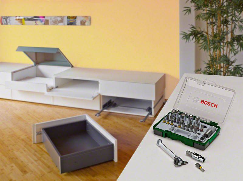 Bosch tool case on a table, surrounded by drawers and a mounted cabinet in the background, showing furniture assembly context.