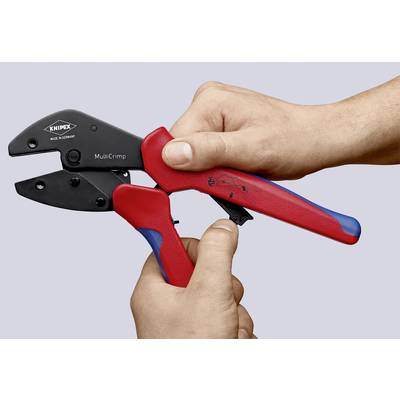 A hand is holding a red and black crimping pliers by the brand 'KNIPEX', model 'MultiCrimp'.