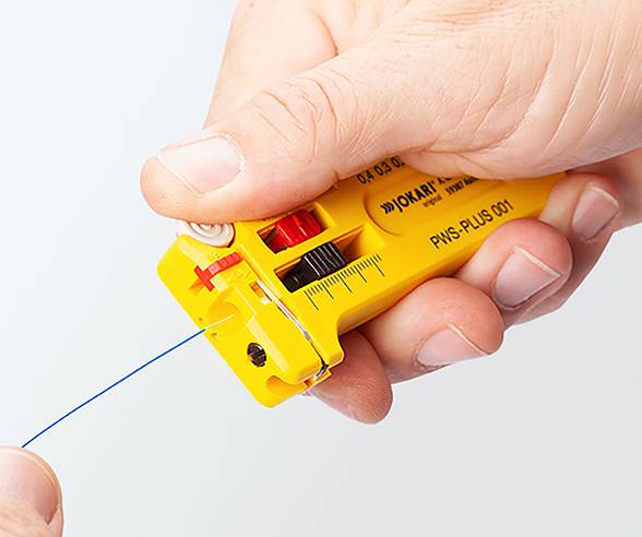 'A person uses a yellow wire stripping tool to strip blue wire.'