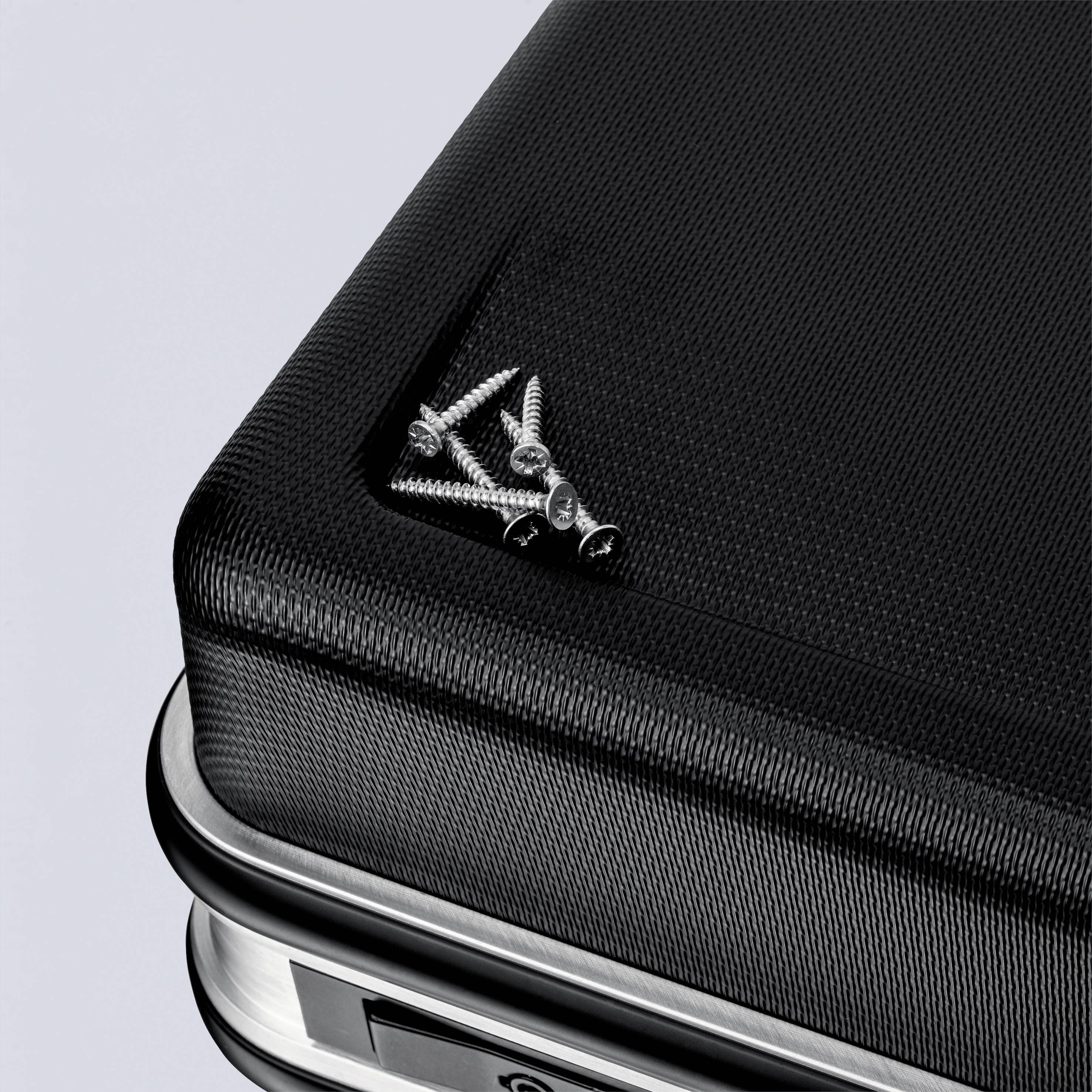 A stack of black textiles with visible screws at the top left of one of the fabrics.