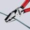A pair of pliers with red handles is cutting a green wire.