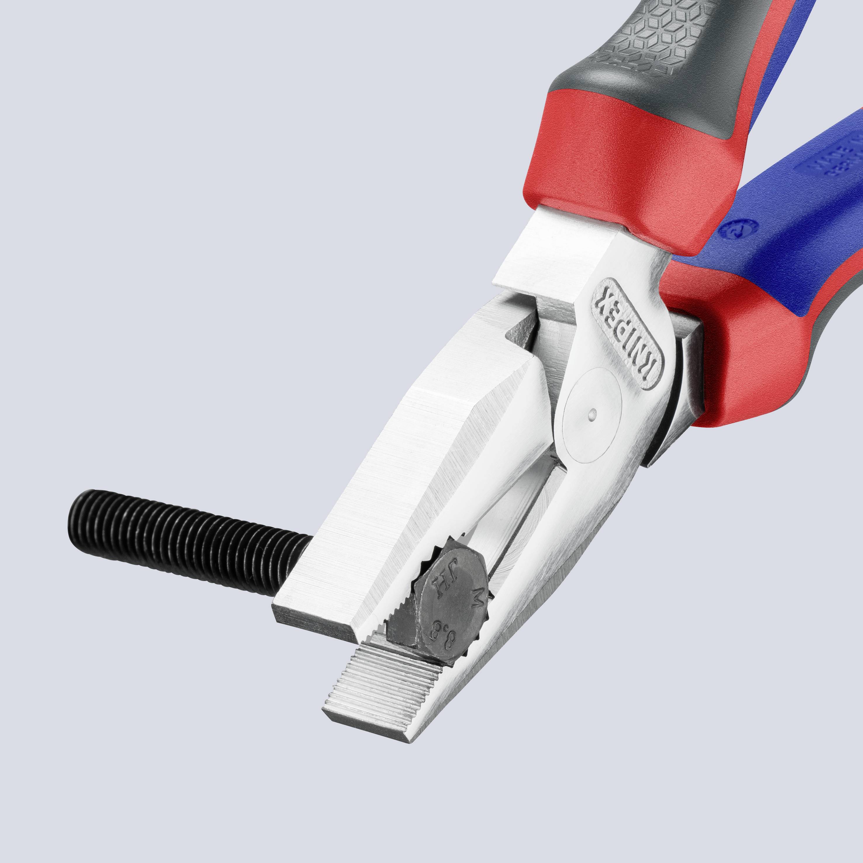 A metal pair of pliers with red and blue handles is gripping a black, ribbed object. Suitable for precise work tasks.