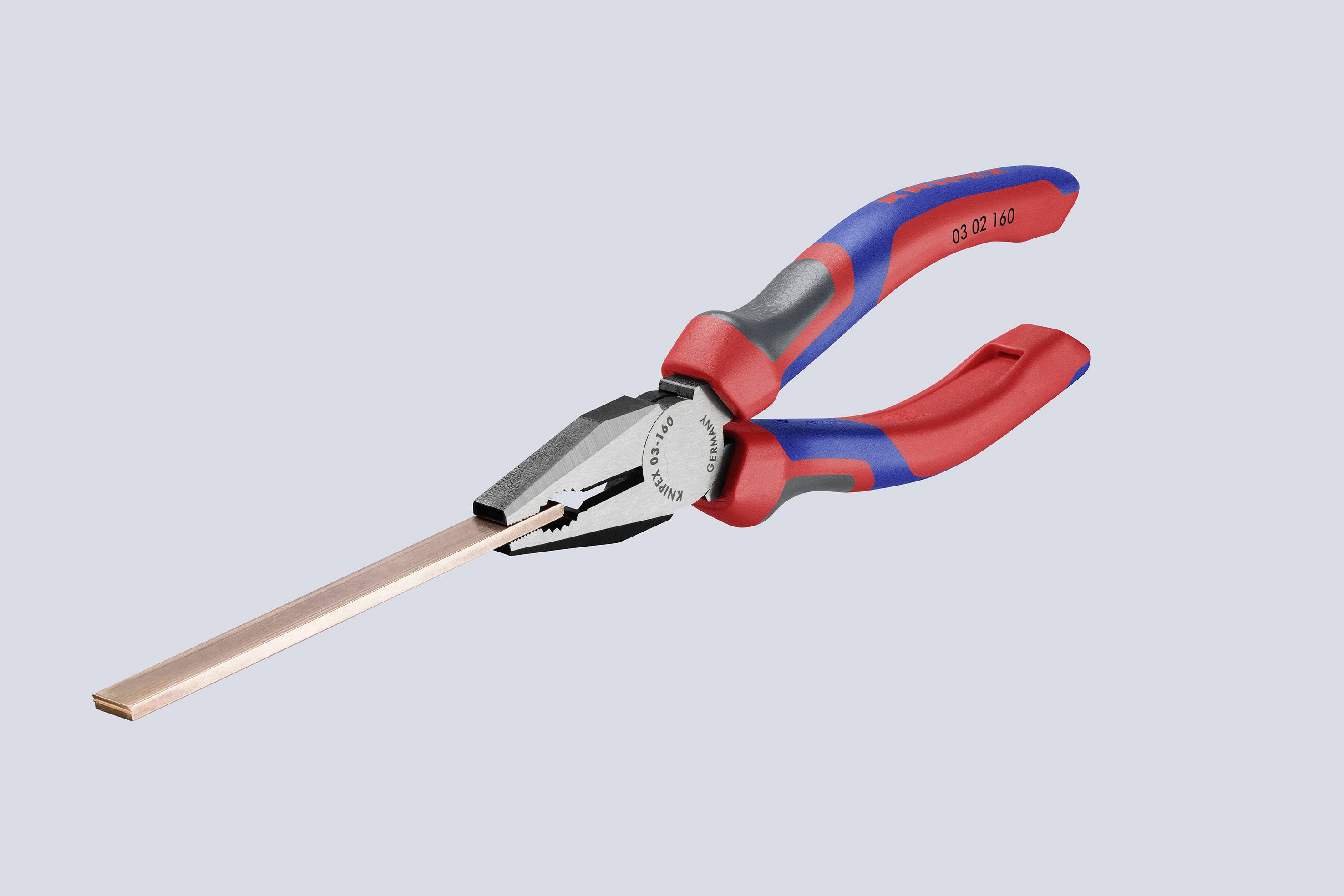 Combination pliers with red and blue handles, holding a flat, copper-coloured metal piece. Suitable for cutting or bending materials.