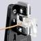 A tool cuts through an orange cable that leads into a transparent connecting clamp.