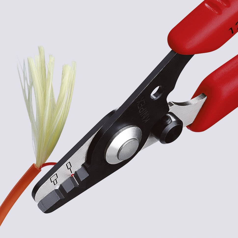 A red pair of pliers cuts through an orange cable, its ends fraying.