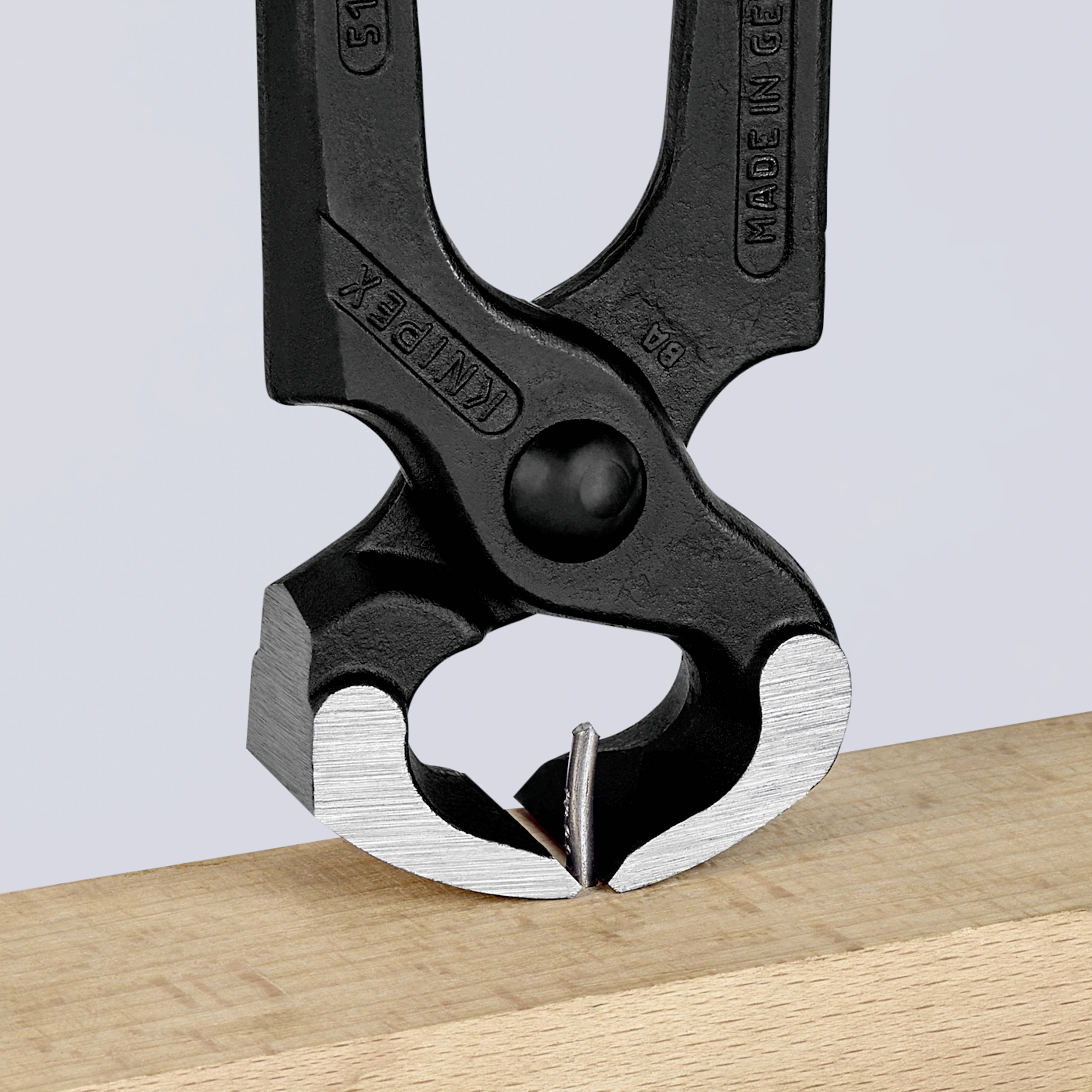 Black nail puller on wooden board. Clip shows stable construction, ideal for removing nails from wood.