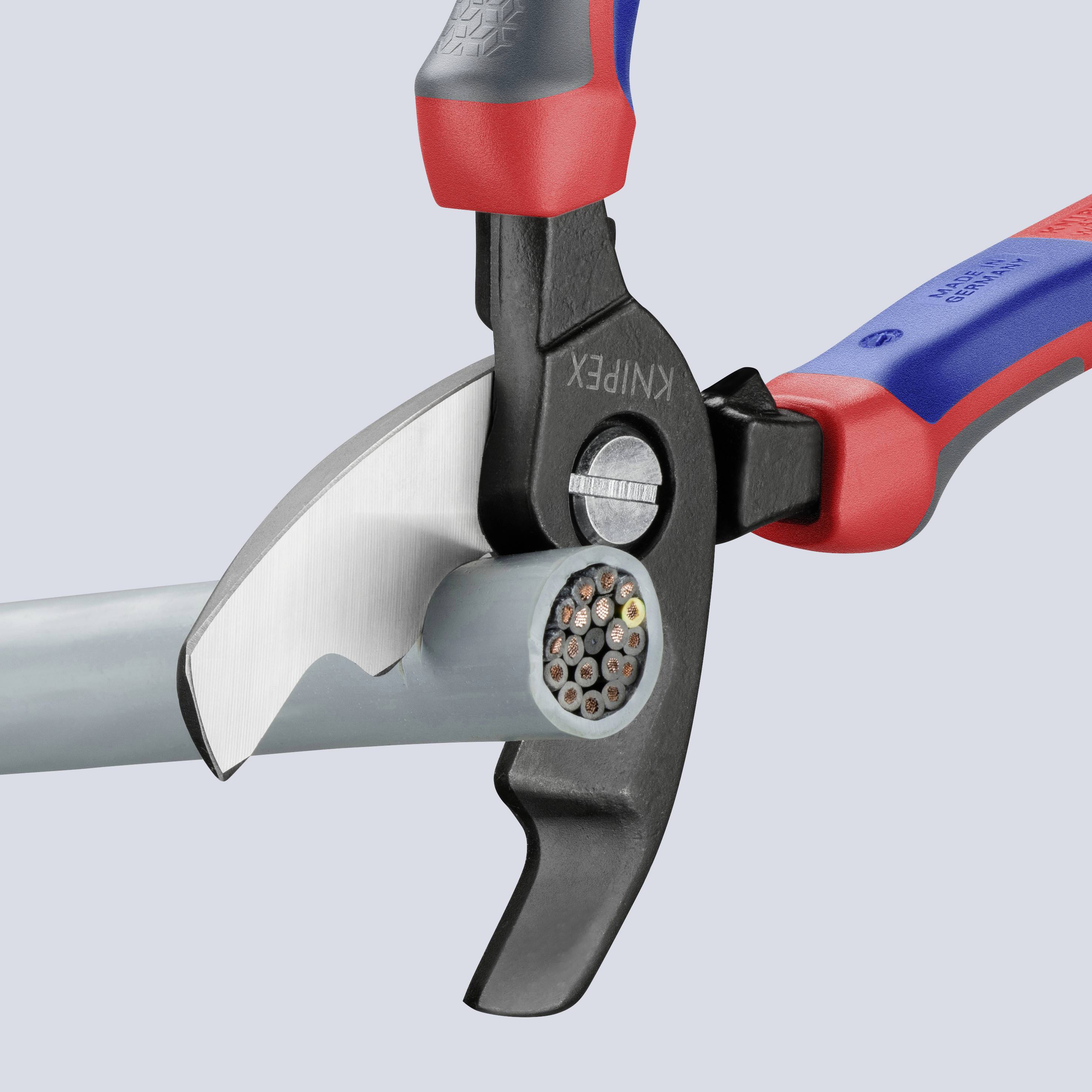 An electrical wire cutter slices through a thick cable with copper wires. The pliers have red and blue handles for better grip.