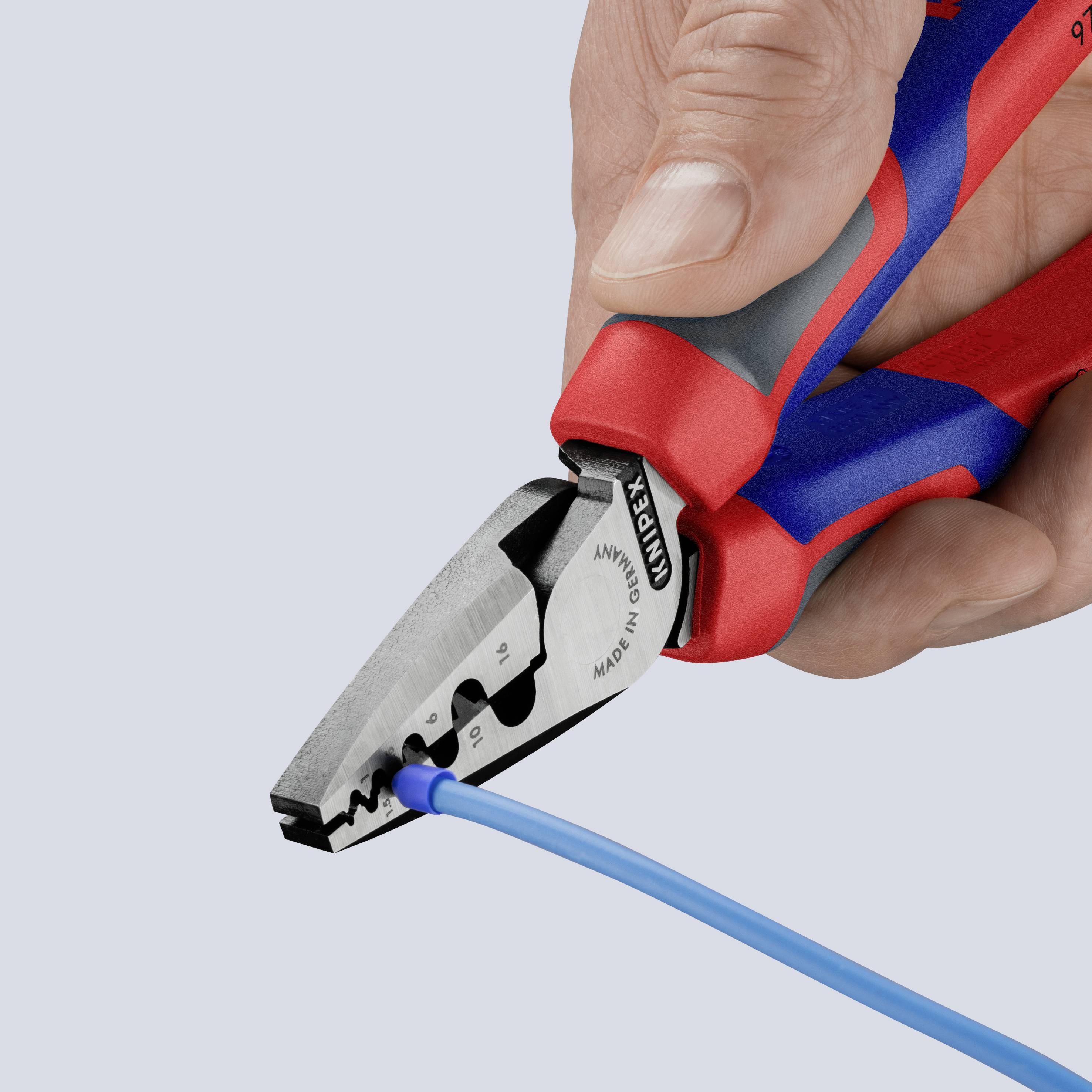A hand is holding a red and blue wire stripper and removing insulation from a blue cable.