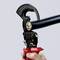Pliers cut thick cable; red handles, black gripping head. Hands holding the tool.