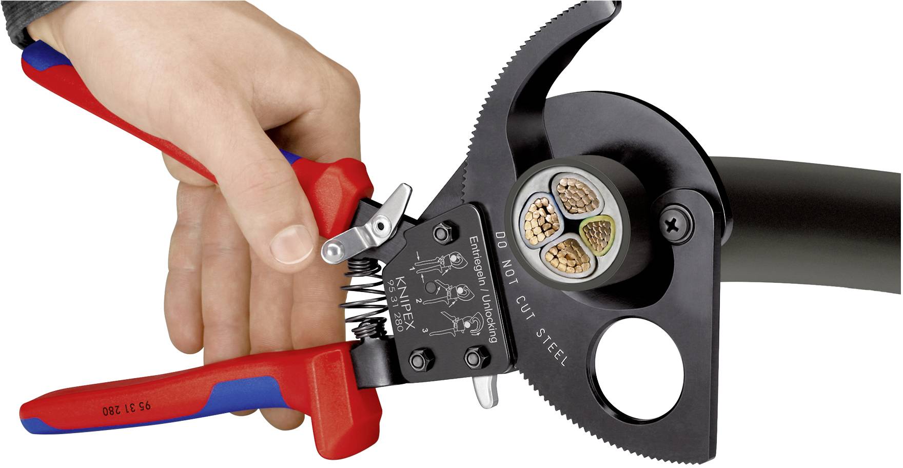 A hand operates a red cable cutter, precisely cutting through a thick cable with visible copper strands.