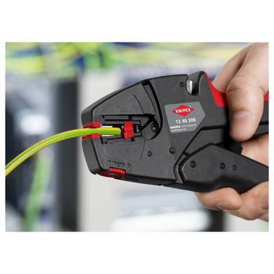 'A hand using a Knipex wire stripping tool to strip an electrical cable, surrounded by blurred cables in the background.'