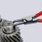 Two metallic gears, turned by pliers with red handles. Mechanical precision and technical application in focus.