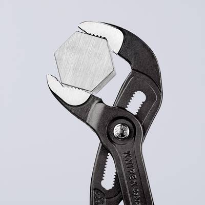 A pipe wrench is holding a hexagonal bolt. It is slightly open, ready to grip or loosen the bolt.