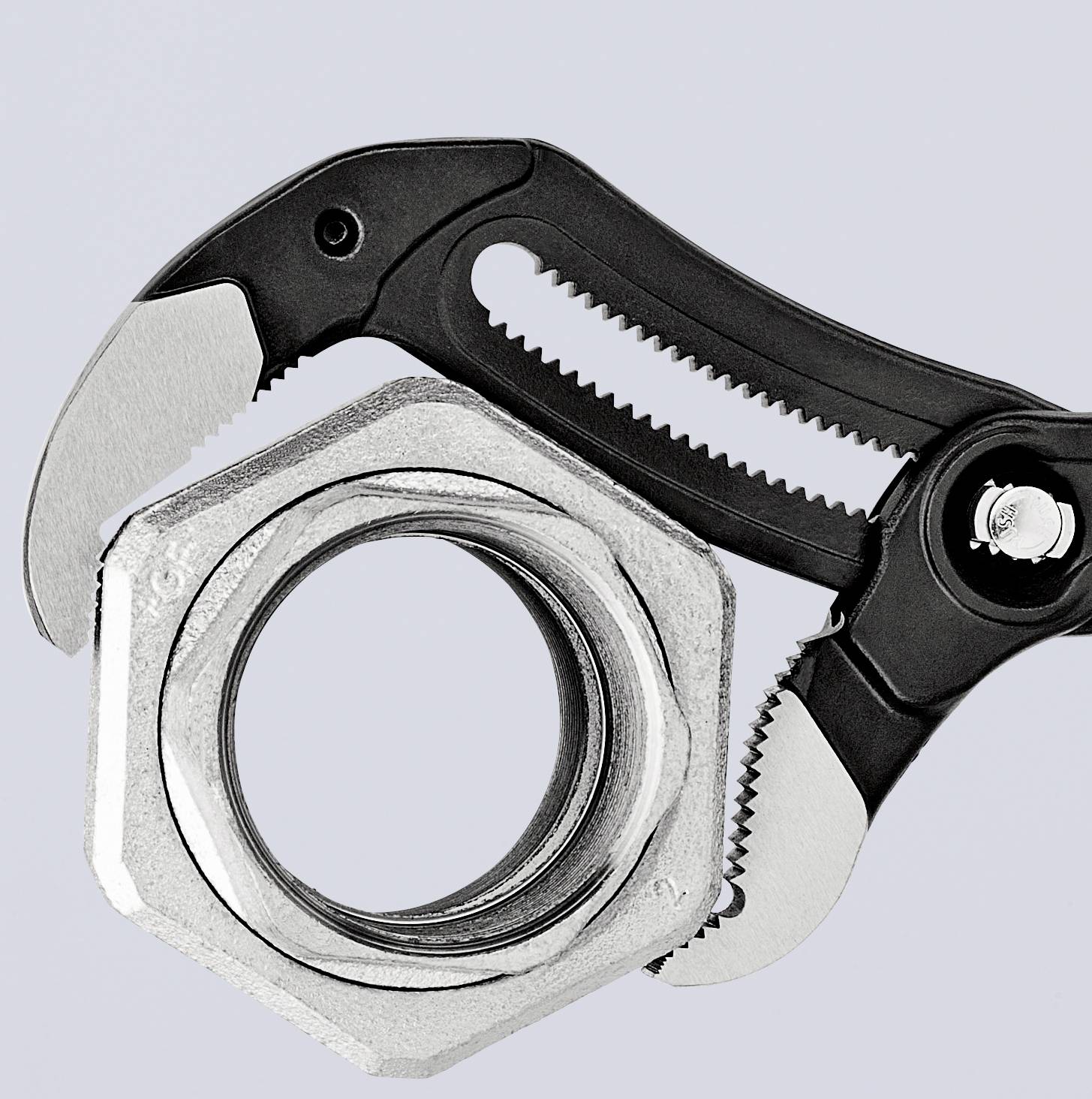 An adjustable spanner is holding a large silver nut.