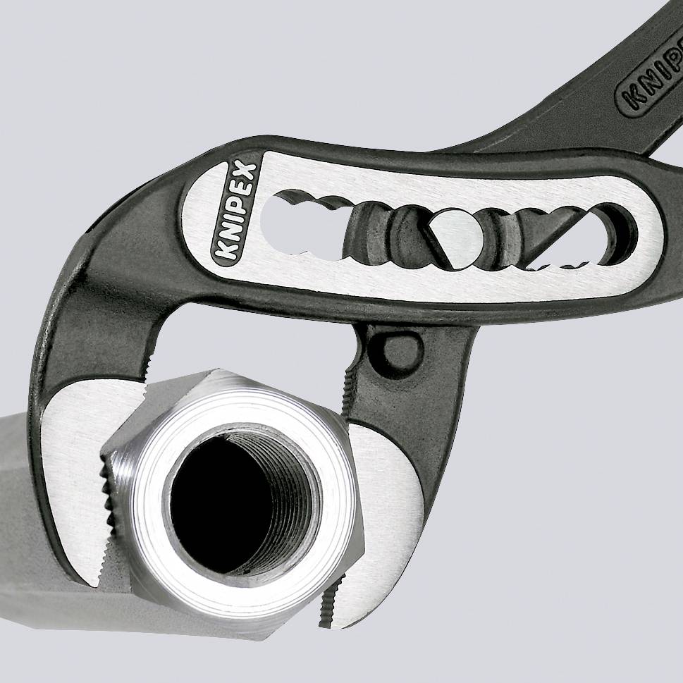 An adjustable spanner grips a chrome-plated nut. The handle shows a toothed opening for adapting to different sizes.