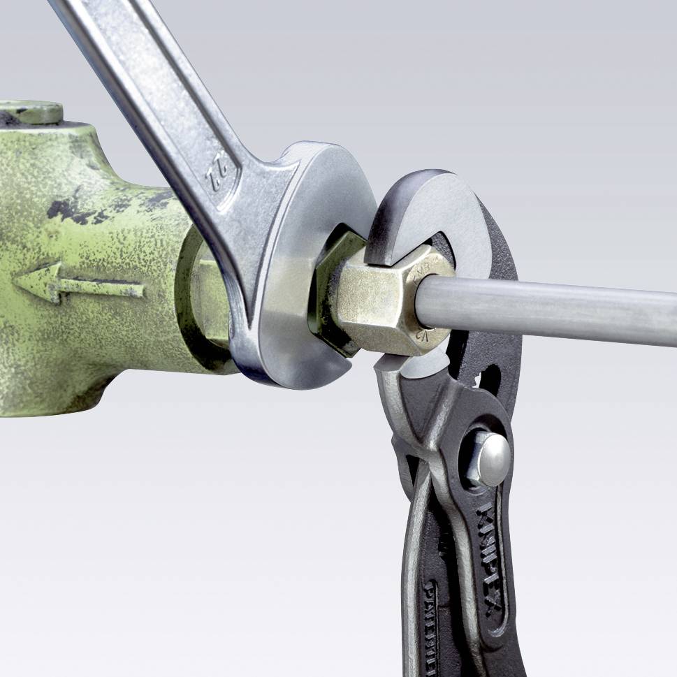 A screw is secured with a spanner and pliers on a green valve.