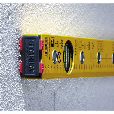 A yellow spirit level is resting against a rough, grey wall, indicating that its position is horizontal.