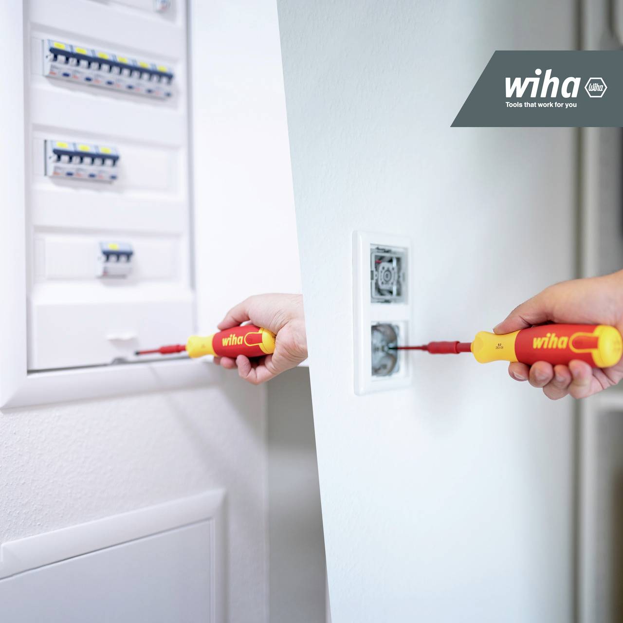 A person is using a screwdriver to install or repair a socket. A fuse box is visible in the background.