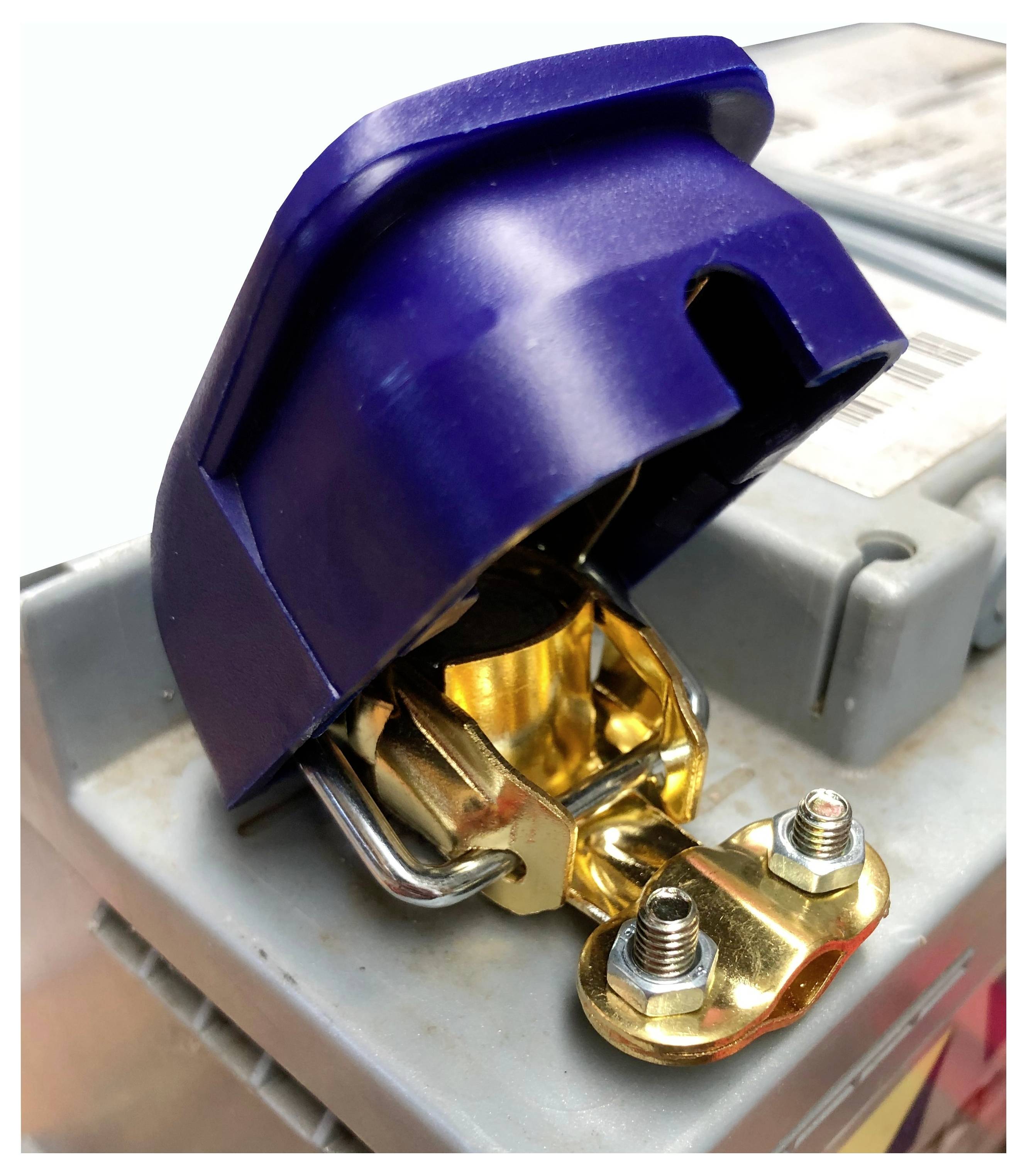 A close-up of a car battery terminal covered by a blue protective cap, with visible bolts and metal connectors.