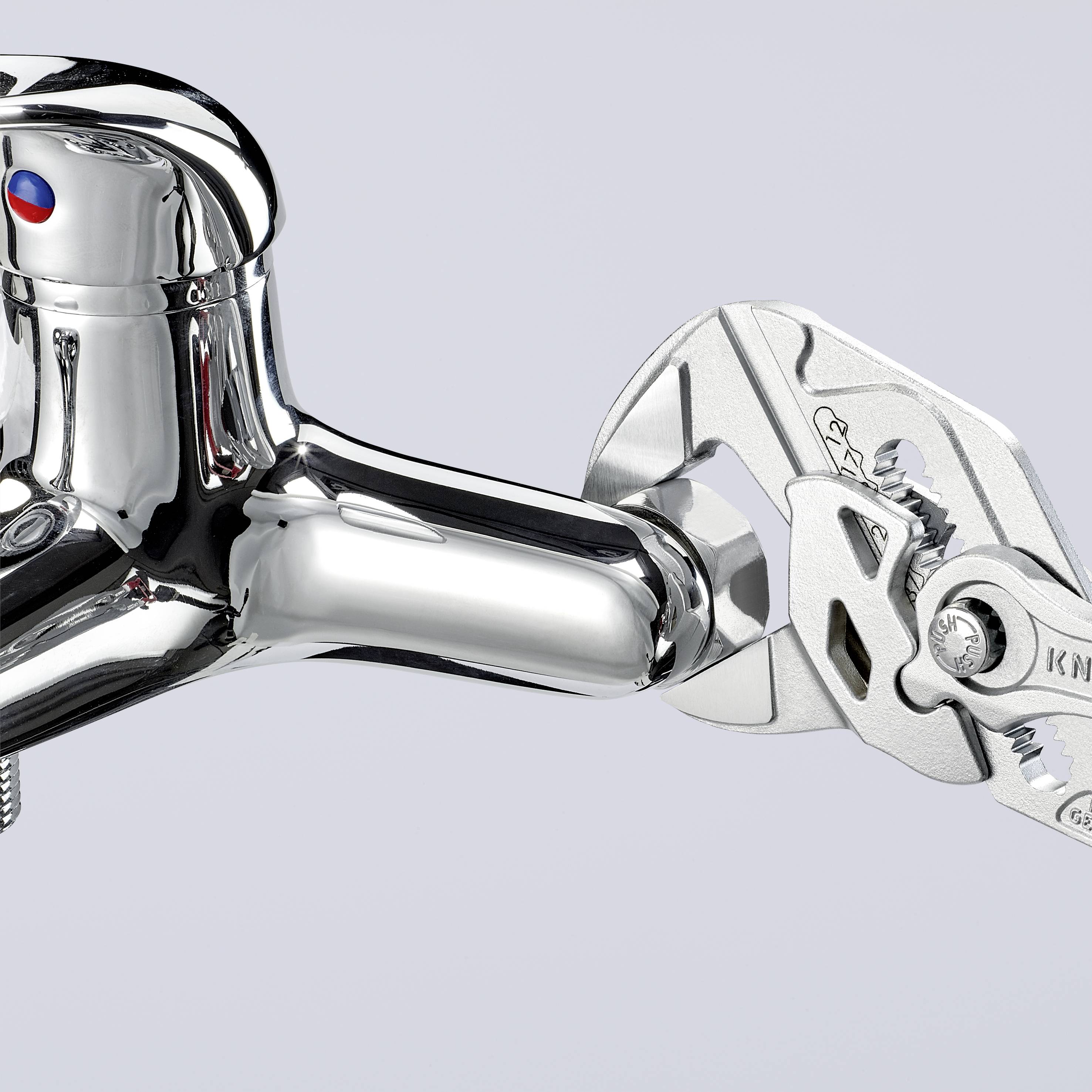 A chrome-plated tap is secured with an adjustable pipe wrench. The background is light grey.