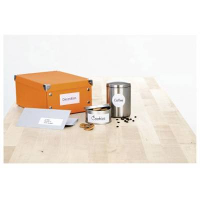 A table with an orange box, a metal tin labelled 'Biscuits', a coffee jar and scattered coffee beans.