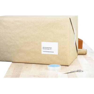 A brown-wrapped parcel with a white address label lies on a table. Beside it are sellotape and scissors.