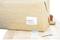 A brown-wrapped parcel with a white address label lies on a table. Beside it are sellotape and scissors.
