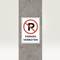 'No Parking' road sign on grey post indicates parking restriction.