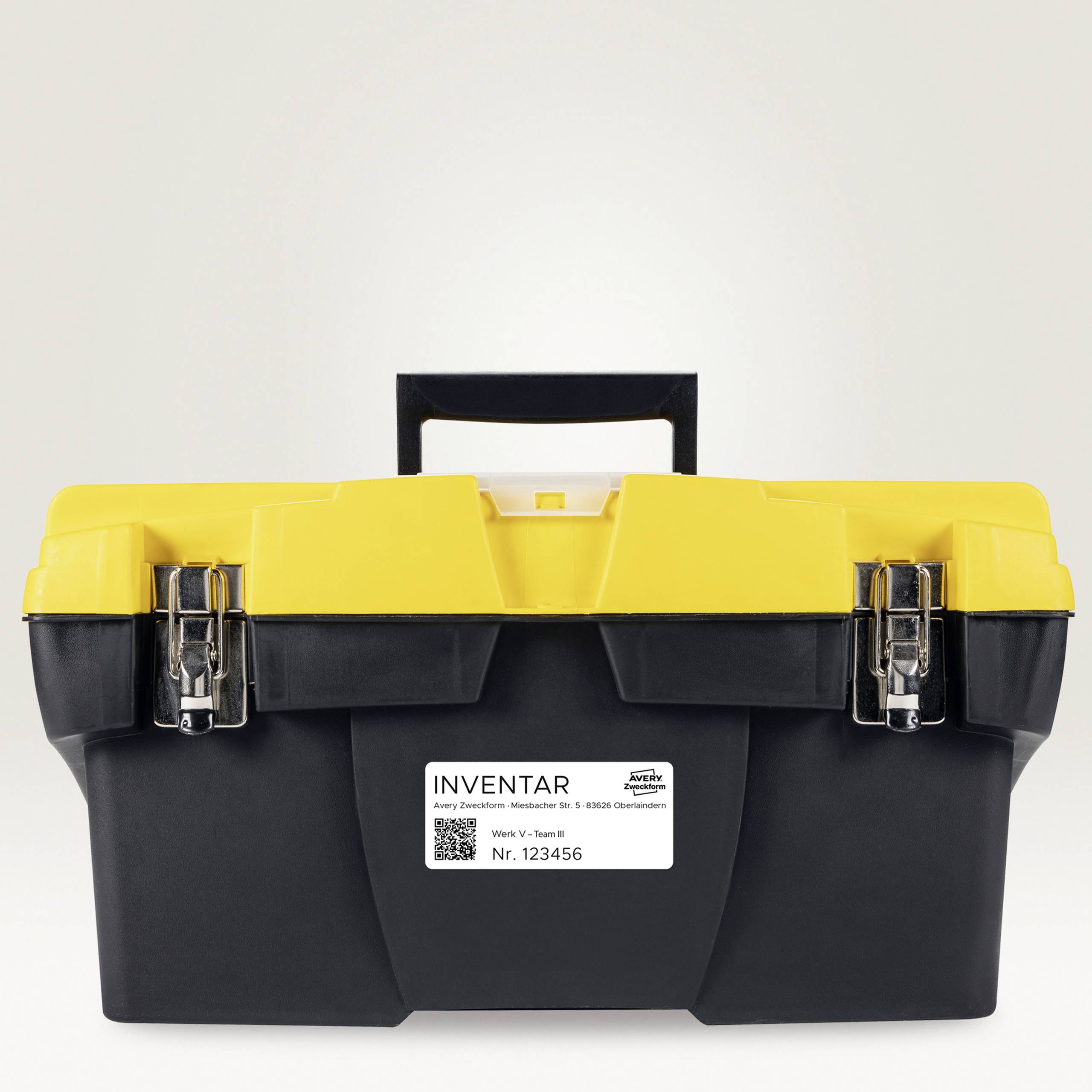 A yellow toolbox with black edges and a white inventory label with the number '123456' on the front.