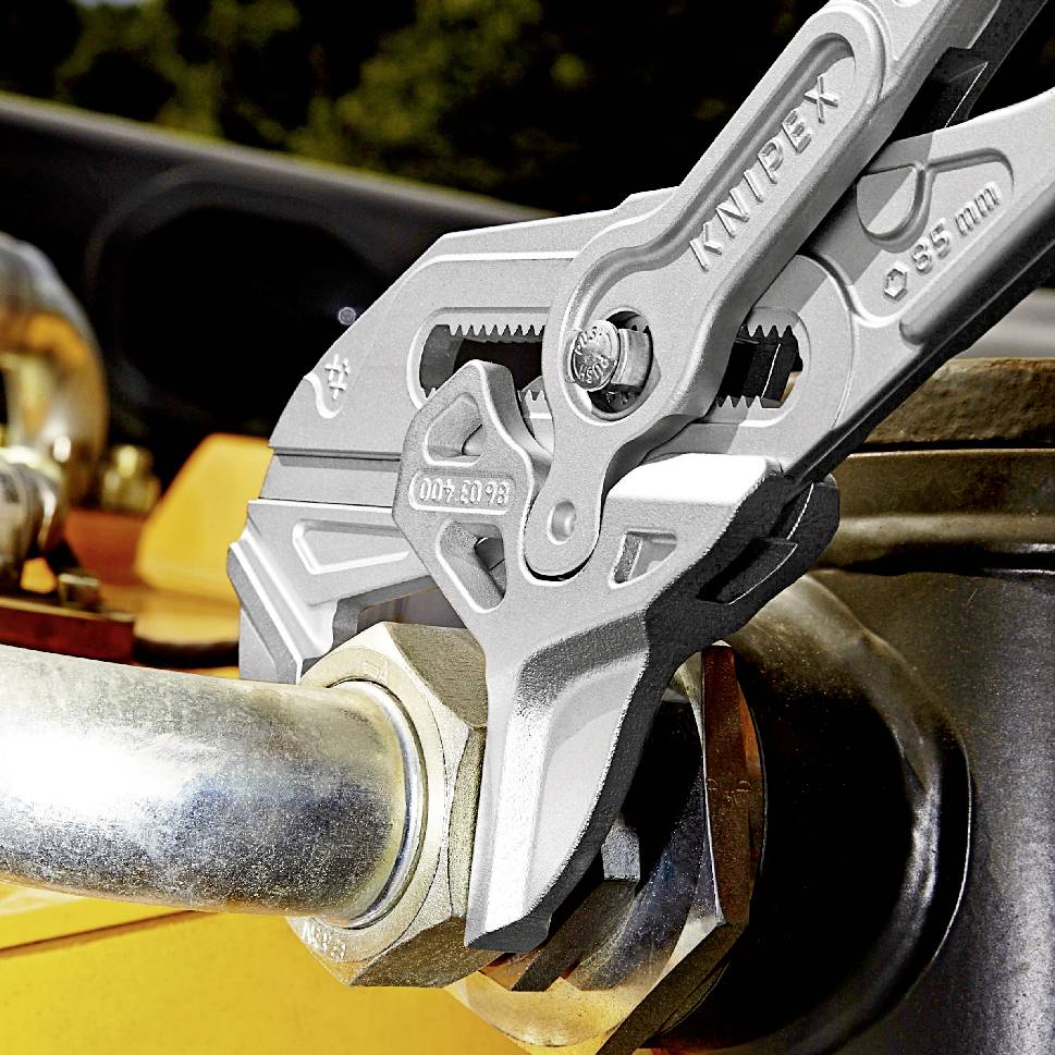 An adjustable pipe wrench grips a metal pipe firmly. The wrench shows the embossing 'KNIPEX' and the measurement marking 'Ø 35 mm'.