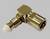 A metallic right-angled adaptor, suitable for connecting two coaxial cables, on a grey surface.