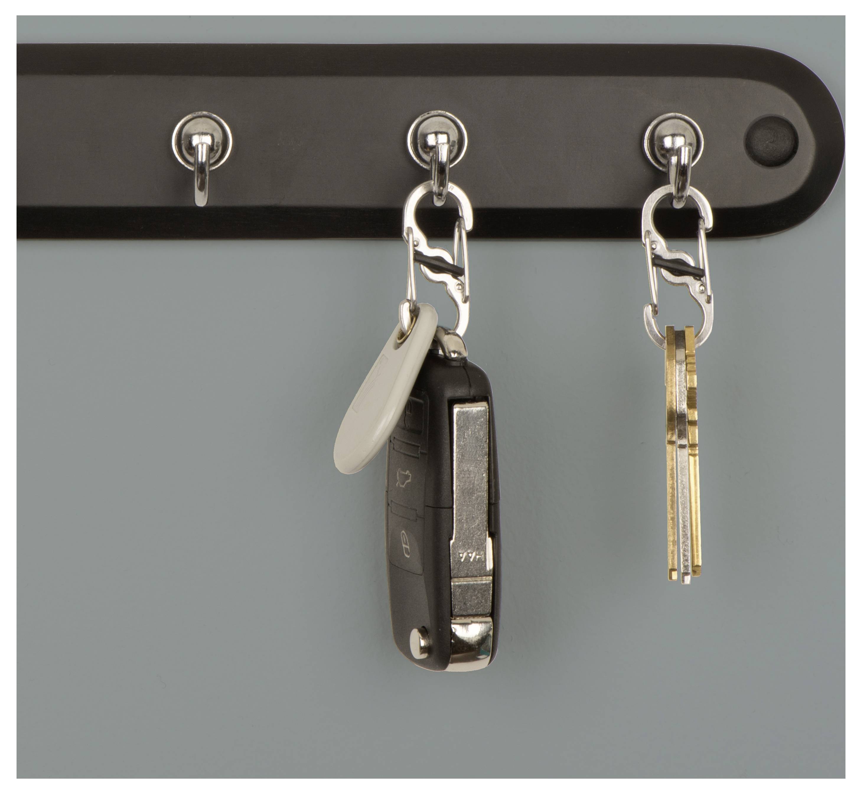 Car key and house keys hanging on hooks.