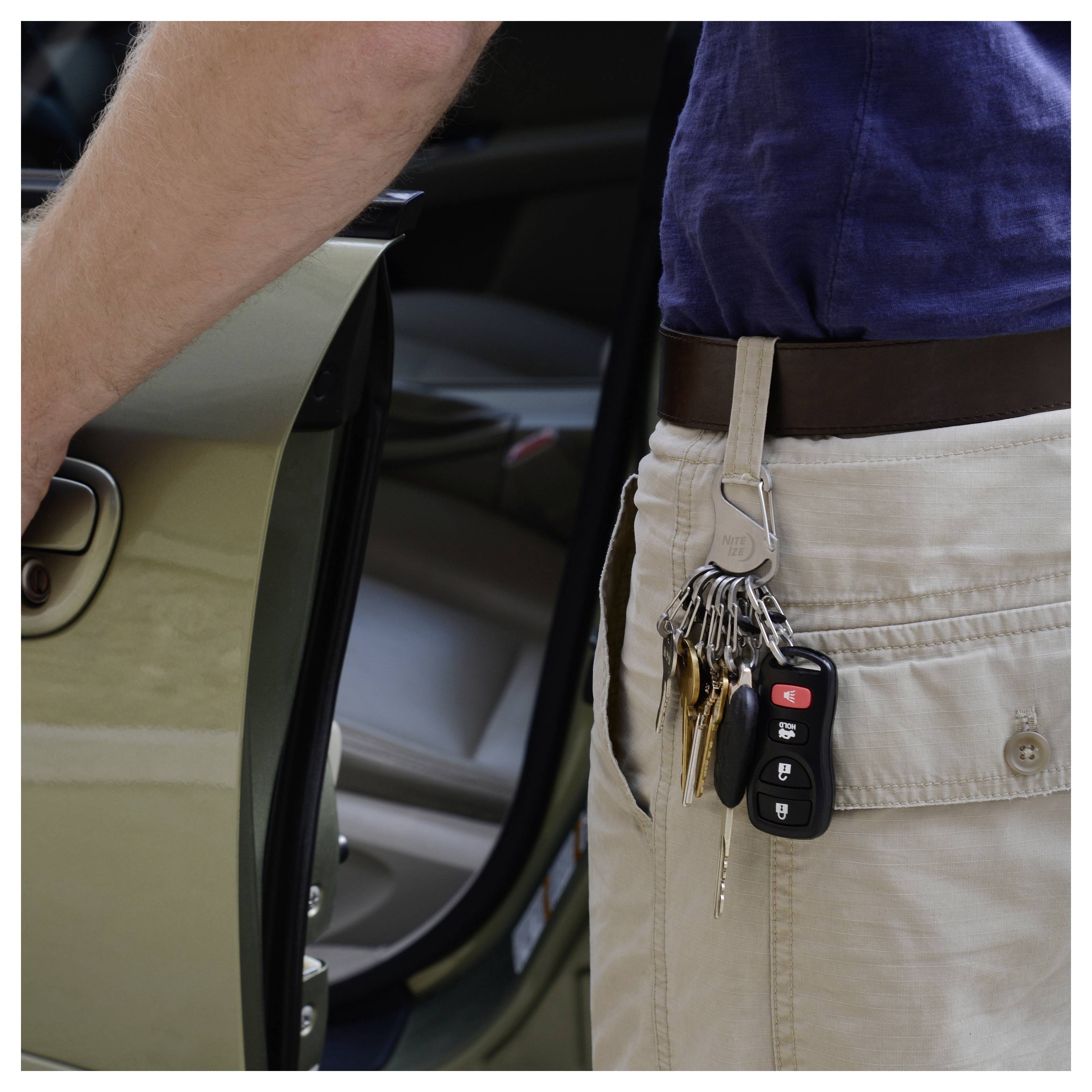 A person with a car key in their pocket is unlocking a car door.