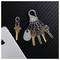 A set of six keys attached to a 'Nite Ize' key holder on a black textured background, next to a smartphone and a single loose key.
