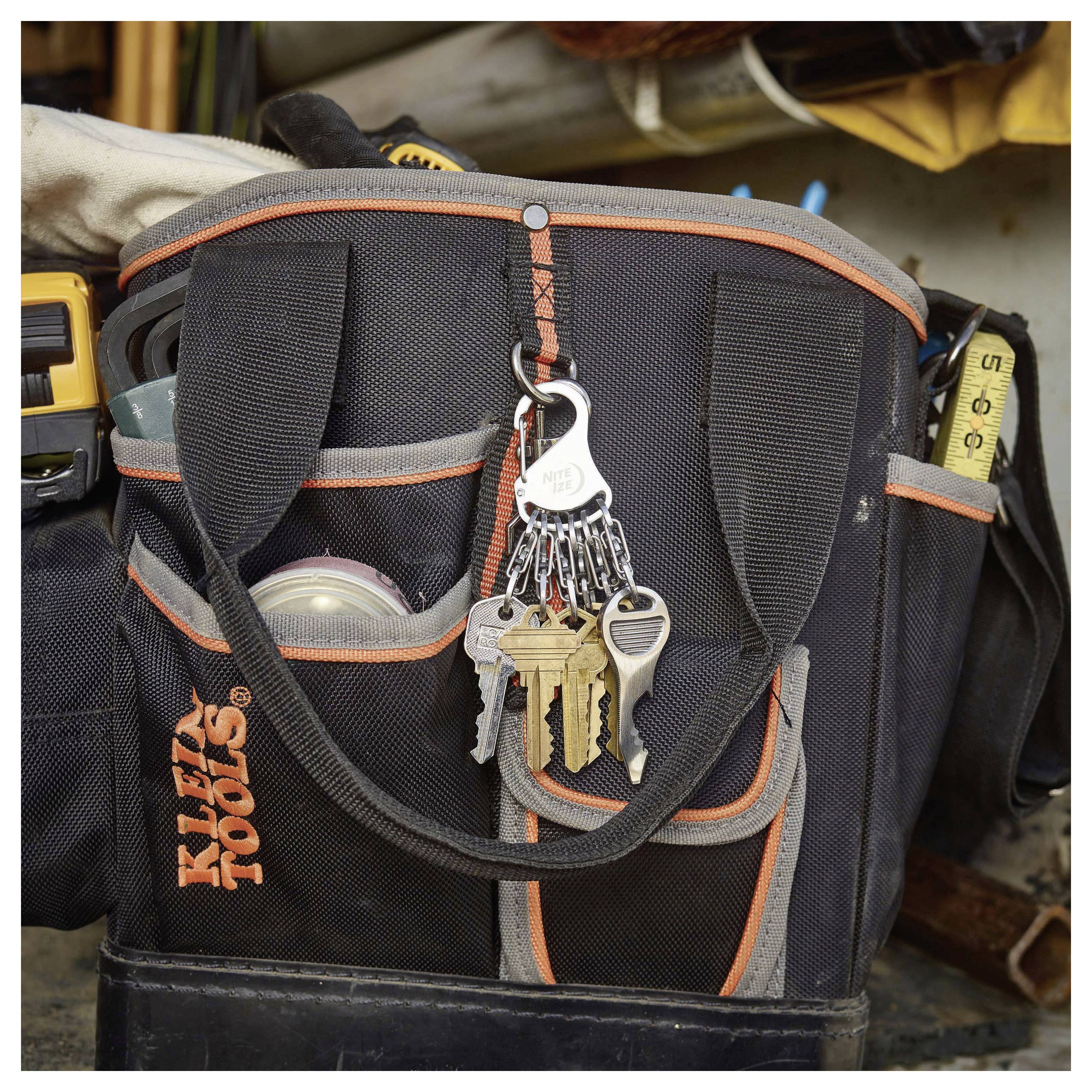 A black and orange tool bag with multiple compartments is organized with keys attached to a silver ring on the front. Various tools are visible.