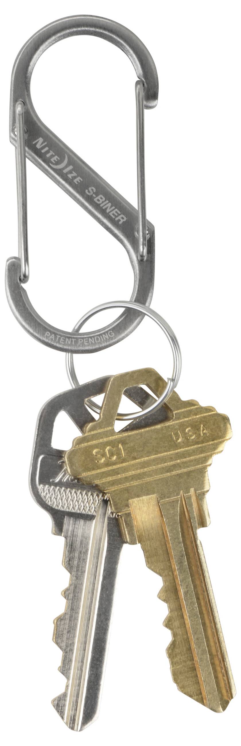 A silver carabiner clip holding three brass keys on a keyring.