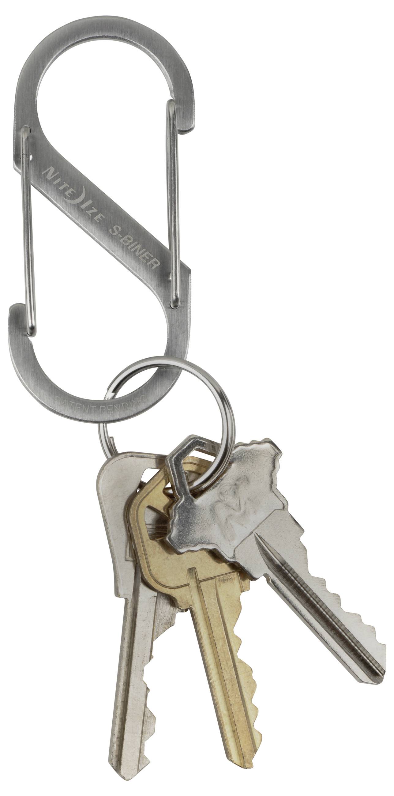 A small carabiner with three attached keys: two silver-colored, one gold-colored.