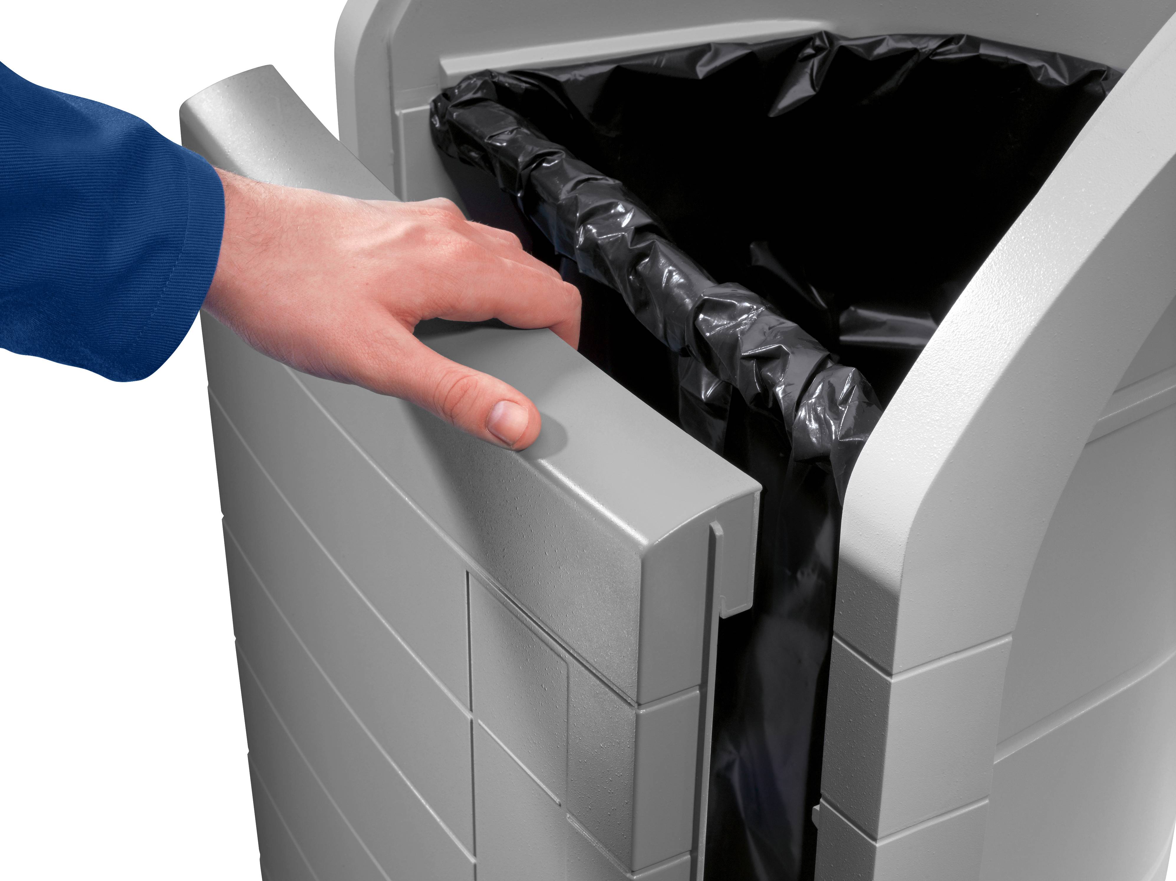A hand opens a grey rubbish bin with a black bin liner.
