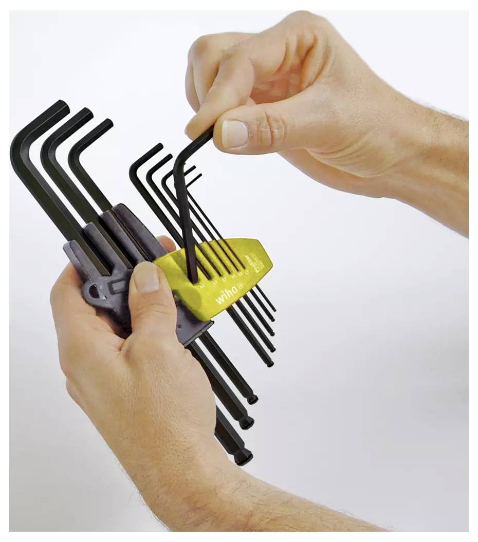 A person selects an L-shaped Allen wrench from a yellow holder containing different-sized wrenches, suggesting tool organization and selection.