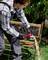 A person is using an angle grinder to cut a metal object outdoors. Sparks are flying from the grinding disc.