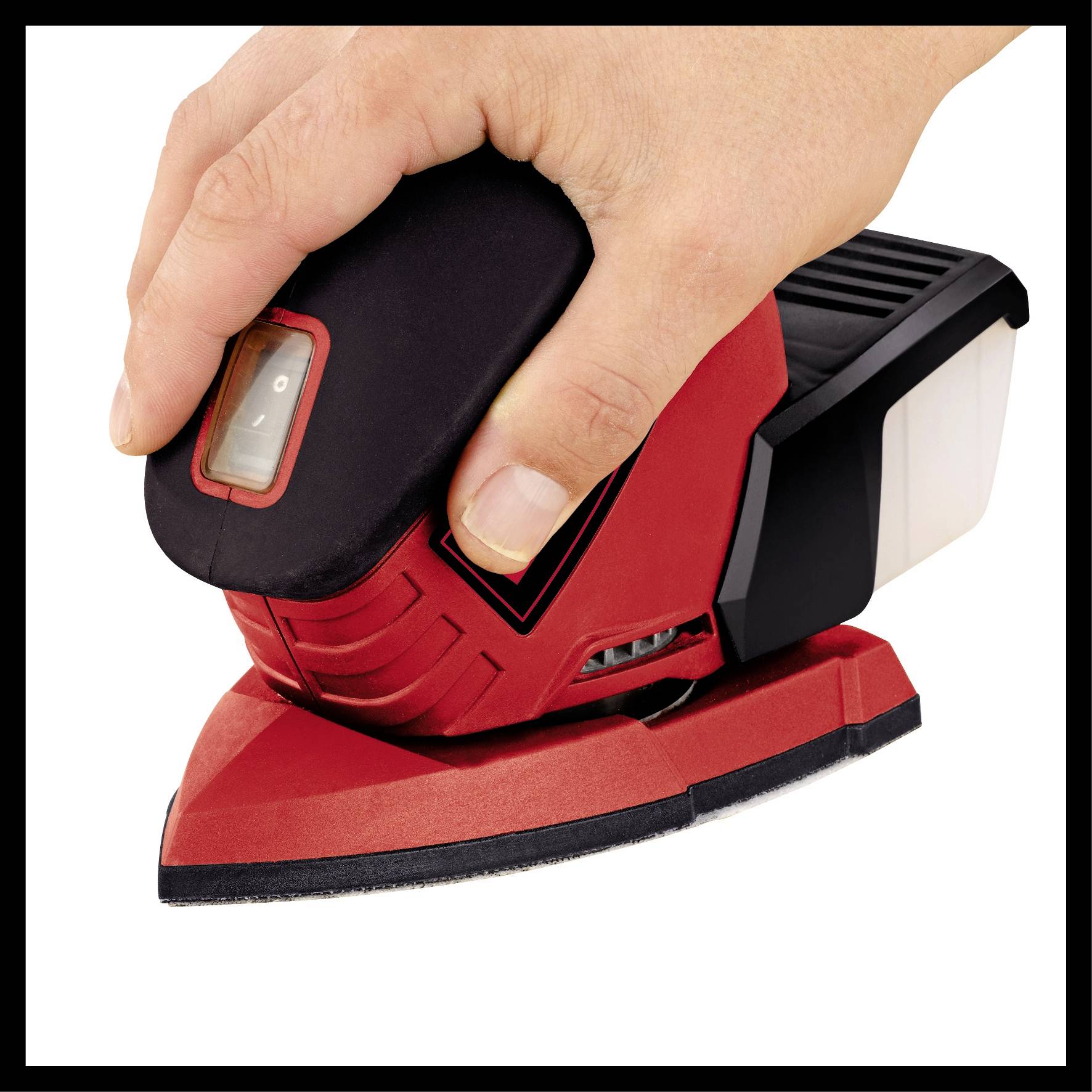 A hand is operating a red electric sander on a flat surface. The sander has a triangular sanding pad.