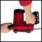 A person is holding a red electric chainsaw, ready for use. Focus is on the hands and the chainsaw.