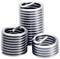 Three silver metal spiral thread inserts, stacked and placed side by side. They are commonly used for repairing damaged threads.