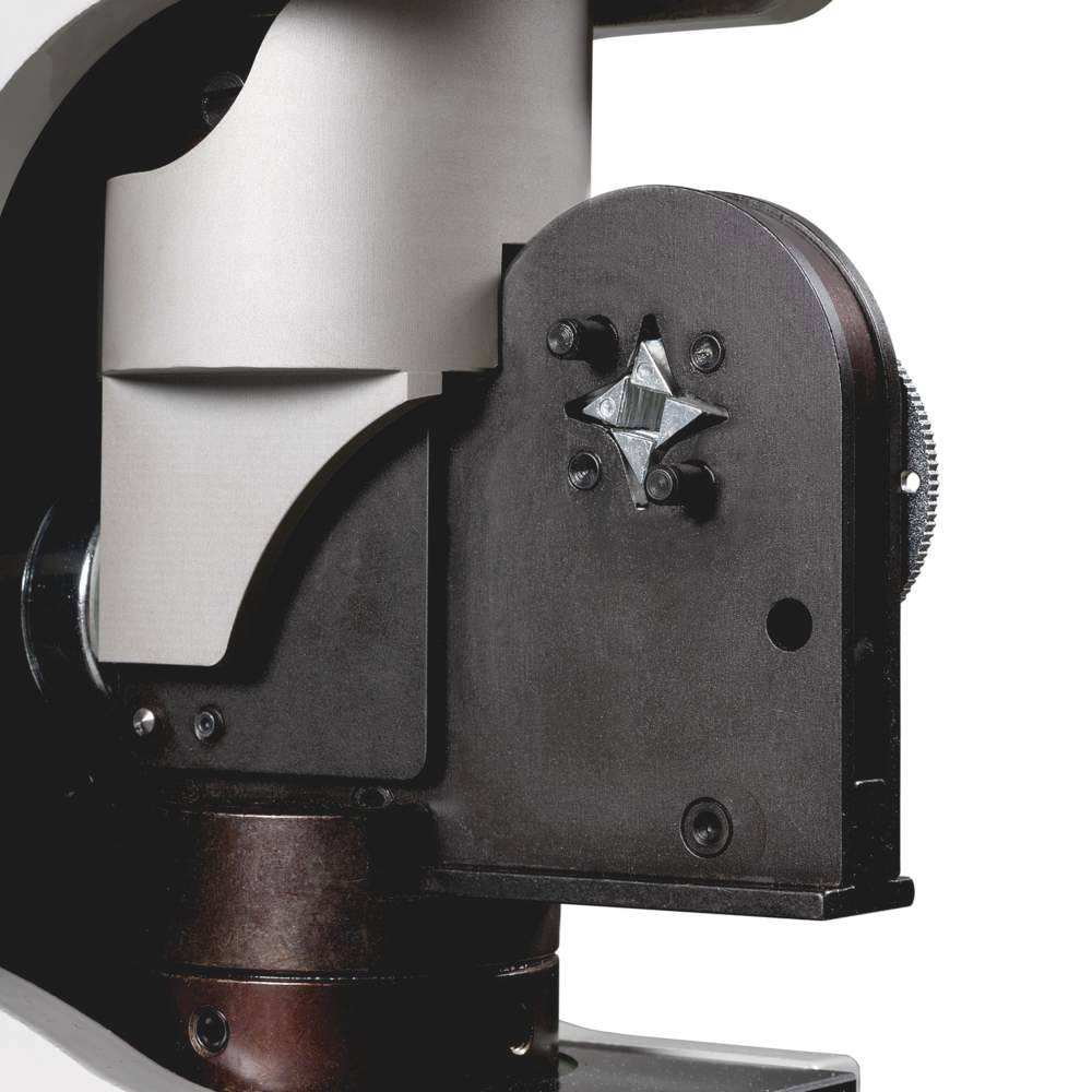 Close-up of a microscope condenser with lenses and mechanisms for light focusing and magnification.