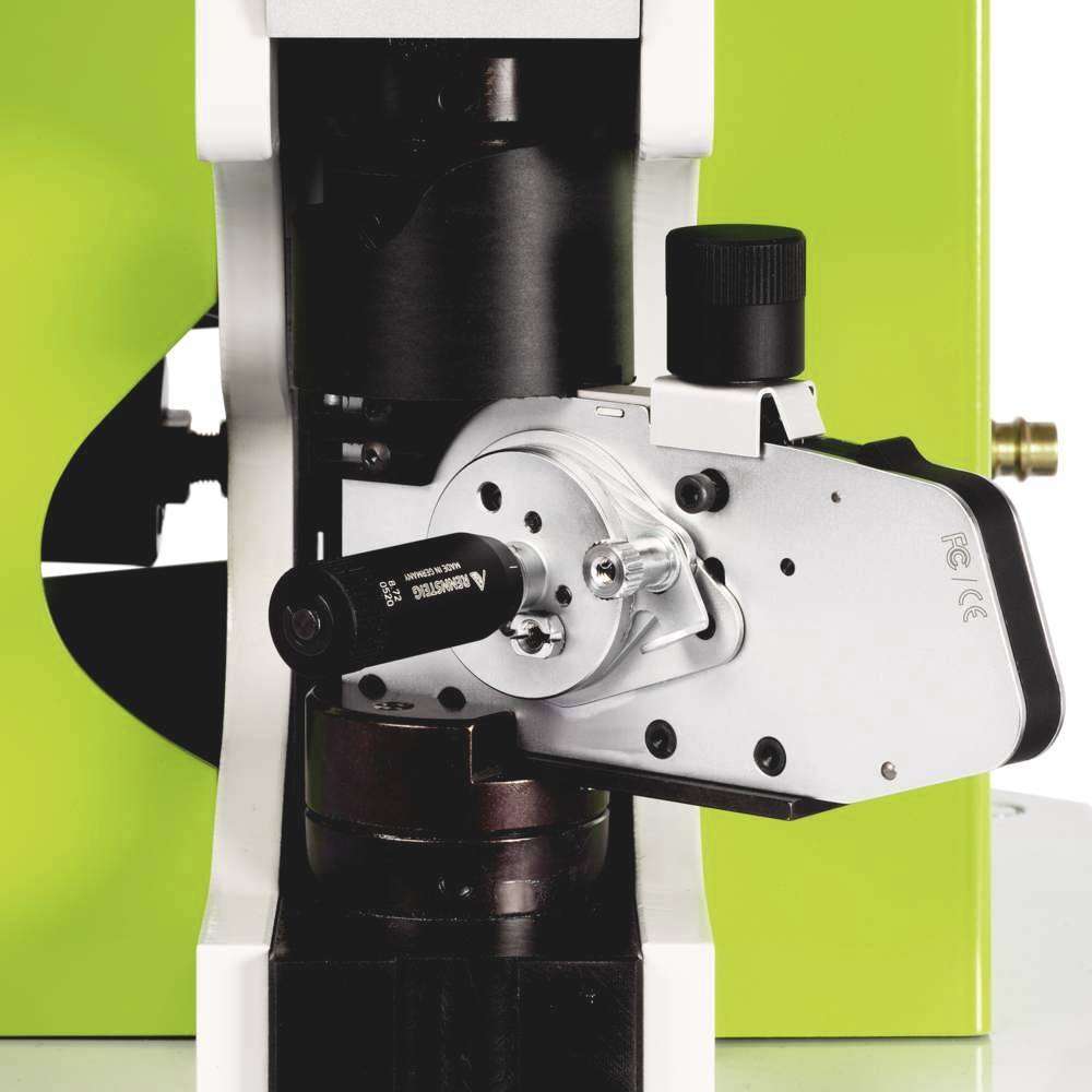 A microscope with a special attachment for magnification and focusing. It has a green frame and is ready for use.