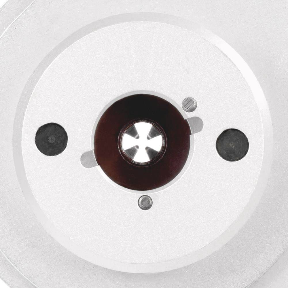 A silver, round object with a dark, star-shaped pattern in the centre and two black circles on either side.