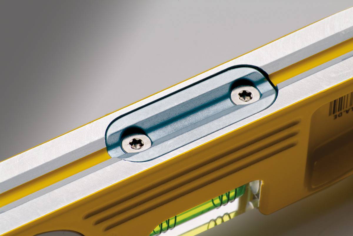 Close-up of a yellow spirit level showing the bubble vial and two screws at the top. Ideal for precise levelling.